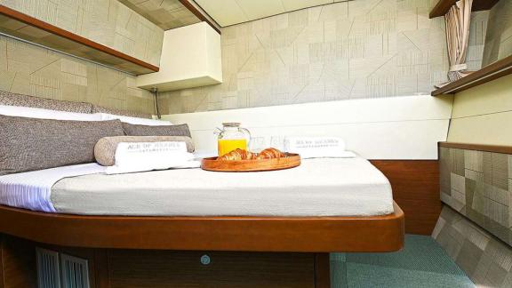 The double cabin of Ace of Hearts in Athens features a large bed, side shelves and an overhead window.