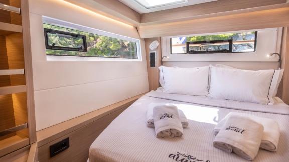 The master cabin of Aranel catamaran in Lefkada features a large bed, side windows and a skylight.
