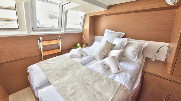 Comfortable cabin with double bed, soft pillows, and large windows on Lagoon 450F Adriatic Tiger