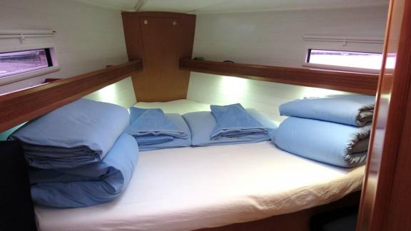 The spacious double cabin of sailing yacht Almina is furnished with a comfortable bed and pillows.