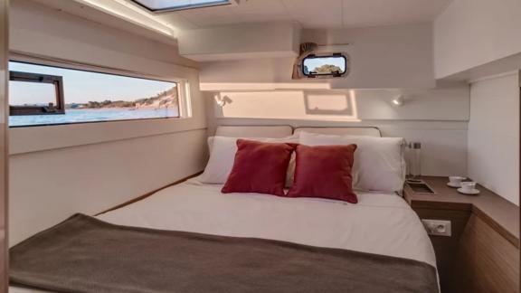 Comfortable cabin with large windows and double bed, perfect for relaxing nights on board.