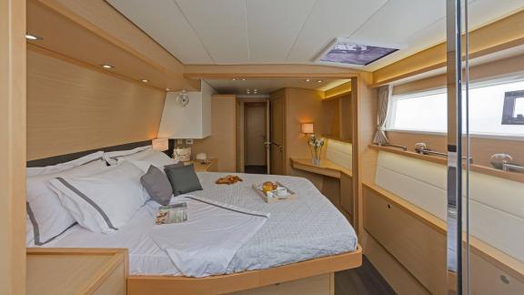 Spacious and cozy master cabin on the Lagoon 560 S2 Meliti with a double bed and modern design