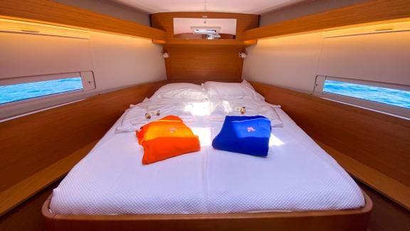 Comfortable double cabin on the sailing yacht Sam's Wind with sea view through the windows.