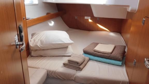 Gemütliches Schlafzimmer auf der Yacht Lina mit sorgfältig angeordneten Kissen und Decken.