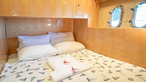 Gästekabine der Motoryacht İmera mit bequemem Bett und Fenstern.