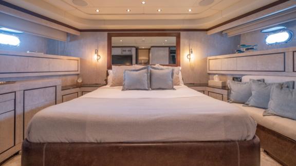 The cabin of motor yacht Five Stars features a large bed and cozy decor elements.