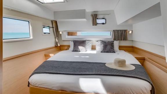 Enjoy restful nights in the elegant bedroom of the Lagoon 42 catamaran with stunning sea views.