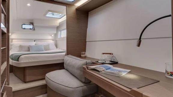 Elegant cabin with a comfortable double bed and workspace, perfect for relaxation and work on board.