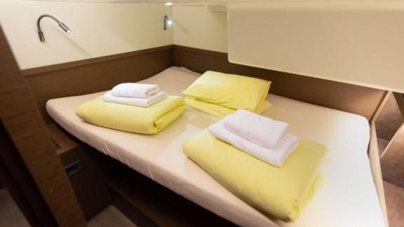 A cozy cabin on the Lagoon 50 with a double bed, reading lamps, and fresh linens for a restful sleep.