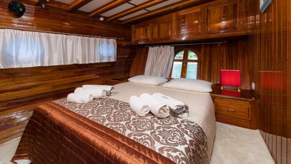 The cabin of gulet Croatia offers a cozy atmosphere with wooden details and a large bed.