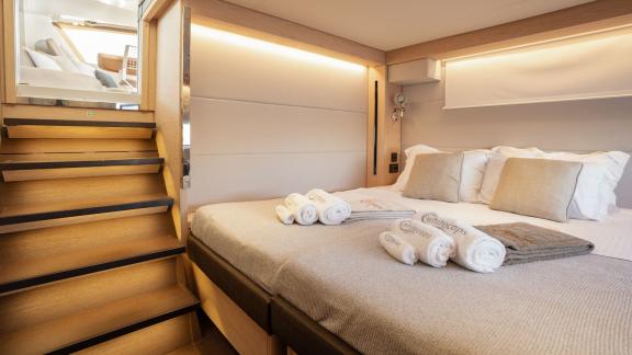 The spacious double cabin of White Caps catamaran is furnished with modern decor for a comfortable sleep.