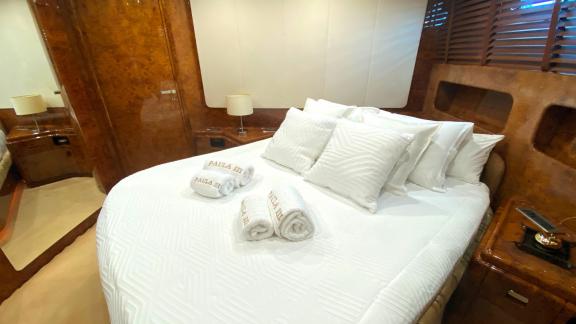 The guest cabin on Paula 3 yacht features a comfortable bed and a simple, elegant decor.