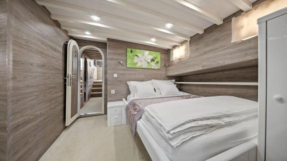 Kabine mit schlichtem, modernem Design, Doppelbett und sanfter Beleuchtung.