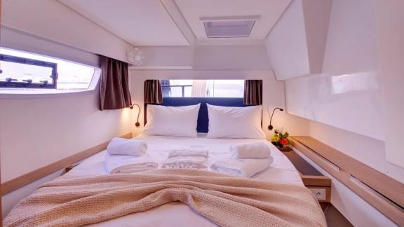 Helidoni charter catamaran cabin features large windows and a bright, cozy bed.