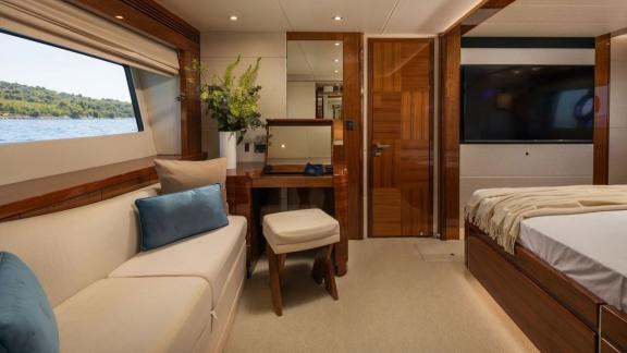 The Sunseeker 75 features a cozy cabin with sofa, makeup desk, large TV and scenic window views.