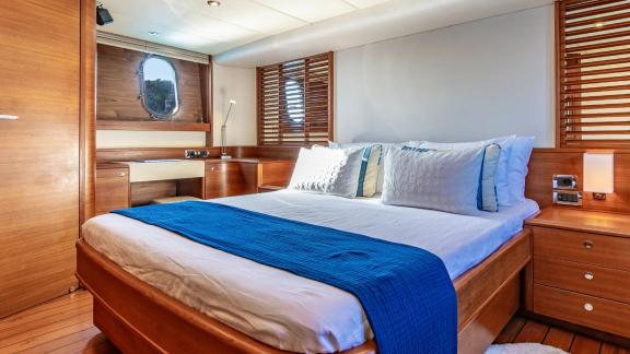 The double cabin of Parodia II in Mallorca features a large bed wooden floor windows and reading lights.