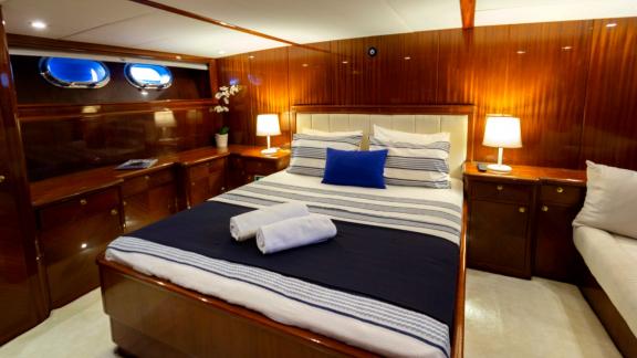 The master cabin of Sveti Sky features a double bed, wooden cabinets and natural light from side windows.