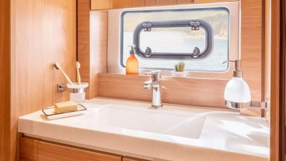 The bathroom on the Sahana catamaran features a spacious sink with a sea view through the window.