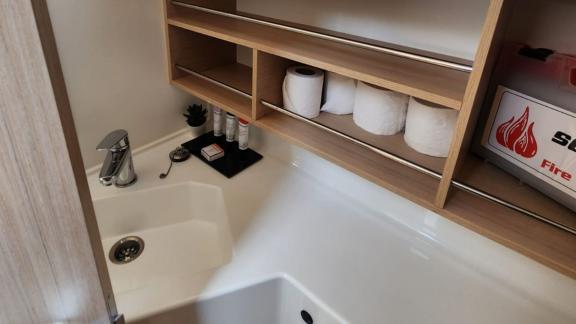 The bathroom of Lima yacht features a sink and practical shelves, providing a clean space.