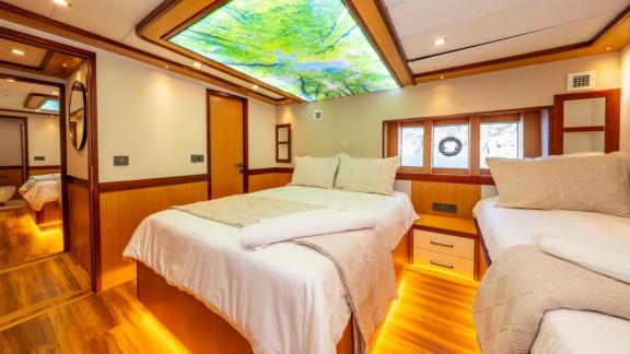 Double bed and warm lighting create cozy ambiance in Lila yacht cabin near Fethiye.