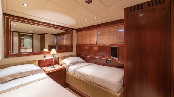 Mangusta 92 Popeye offers a stylish twin cabin with warm tones and wood accents.