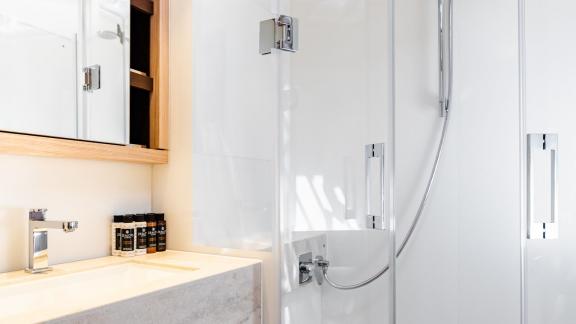 The shower area of White Caps features elegant glass partitions and a minimalist design.