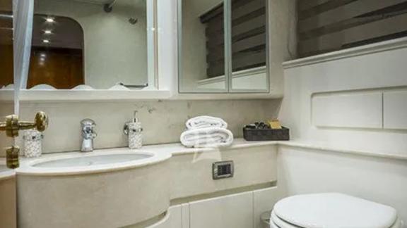 Modern bathroom on yacht Amoraki with mirror, sink, and toilet.