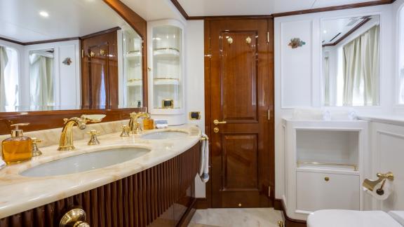 Badezimmer auf der Yacht Stella Fiera mit Doppelwaschbecken, Marmoroberflächen und eleganter Dekoration.