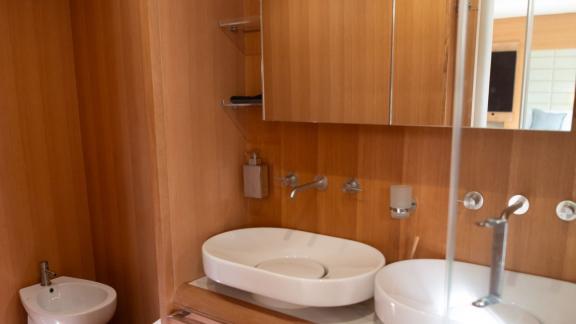 8 Gäste 4 Kabinen Motoryacht Red Rose mit Waschbecken, Spiegel und Holzverkleidung im Badezimmer.
