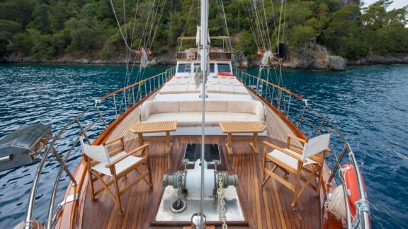 Gemütlicher Sitzbereich auf dem Deck einer Gulet, vor Anker in einer ruhigen Bucht in der Türkei.