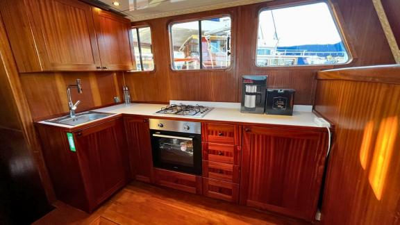 The elegant galley area of the Ahmet Ertürk gulet with its wooden cabinets and modern equipment.