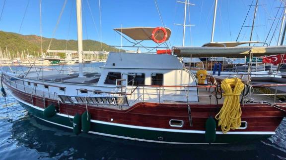 The Gulet Ahmet Ertürk is docked, showcasing its wooden design and deck.