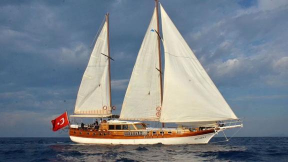 The impressive Gulet Ali Aga 1 with white sails and Turkish flag sailing in Göcek.