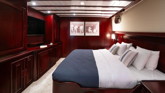 In Göcek gulet charter option Always Smile master cabin with large bed tv unit and cozy interior visible.