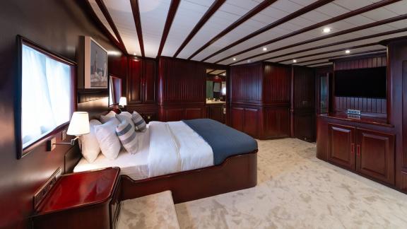 In Göcek gulet charter option Always Smile master cabin with large bed tv unit and spacious interior visible.