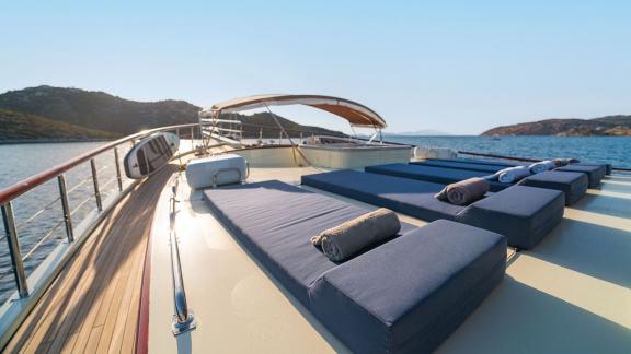In Göcek gulet charter option Always Smile foredeck with sunbeds sea view and spacious lounging area visible.