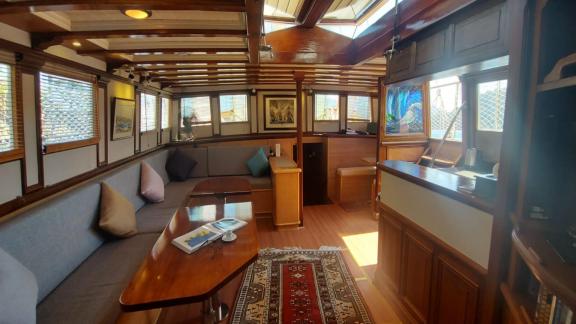 The cosy saloon of the gulet yacht Amazon Solo with wooden furniture and plenty of natural light.