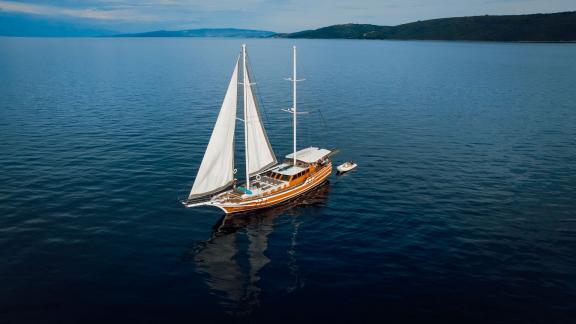 Die hölzerne Gulet Andeo segelt auf ruhigem Meer vor der Küste von Split.