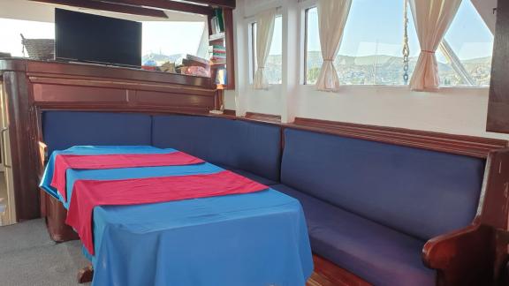 A cozy dining area with blue benches and a table with blue and red covers.