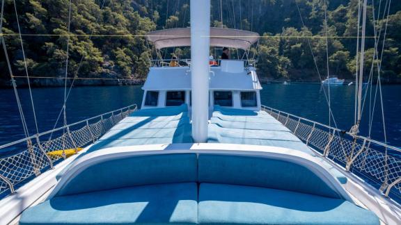 Bequeme Sonnenliegen auf dem Vorderdeck der Gulet Avuncan mit Blick auf das ruhige Wasser der Ägäis.