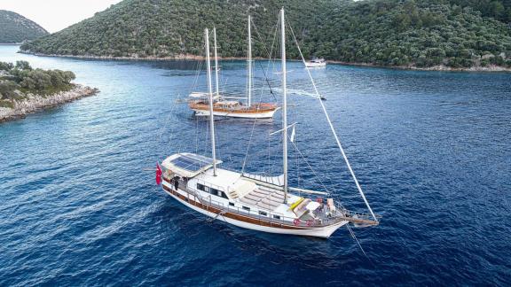 Die elegante Gulet Azura liegt vor Anker in einer ruhigen Bucht in Göcek, umgeben von malerischer Natur.