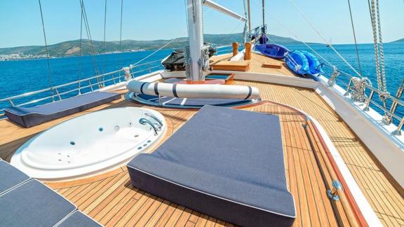 The luxurious sun deck of the Gulet Bella Mare in Bodrum, equipped with sun loungers, a jacuzzi