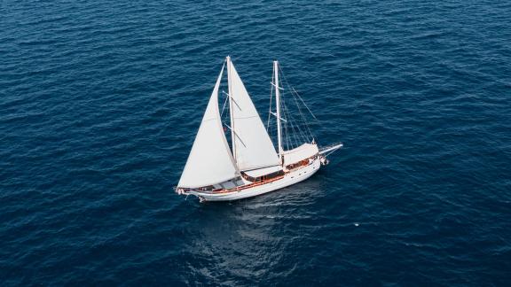 Elegantes Gulet mit 4 Kabinen segelt durch das tiefblaue Wasser der Ägäis, ideal für exklusive Yachtcharter.