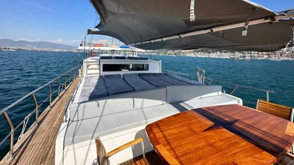 Spacious sun deck with comfortable loungers and shaded dining area on Gulet Bohemian in Turkey.