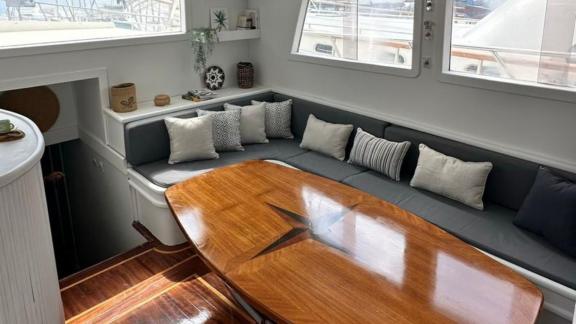 Elegant, light-filled interior dining area with comfortable seating and large wooden table on Gulet Bohemian.