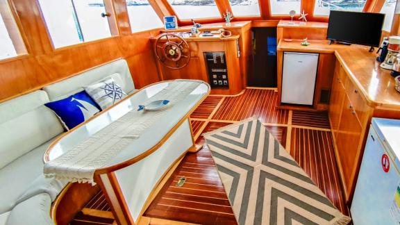 The interior of Gulet Cagan 2 features a stylish seating area with a dining table, a well-equipped kitchen, and the capt