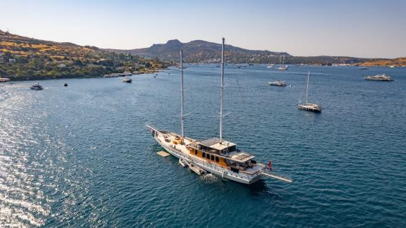 The Gulet Caustic anchored with the picturesque backdrop of Bodrum, perfect for your yacht charter.