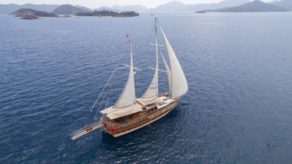 Die Gulet Ceylan segelt im türkisblauen Wasser nahe Fethiye, umgeben von Inseln und Bergen