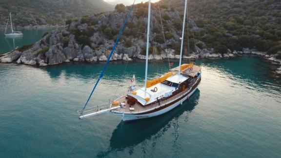 The Gulet Cheers in a picturesque bay in Fethiye, perfect for serene yacht holidays.