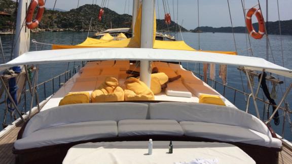 Das gemütliche Sonnendeck der Gulet Cheers mit bequemen Liegen und Blick auf die Küste von Fethiye.